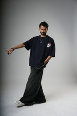 Man wearing a black t-shirt and pants on a gray background