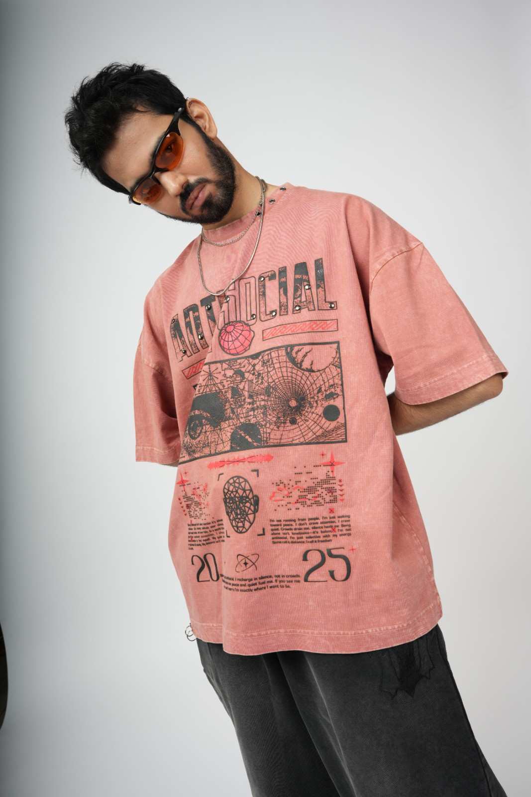 Person wearing a pink graphic t-shirt on a plain background