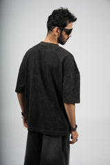 Man wearing a black t-shirt and pants on a plain background