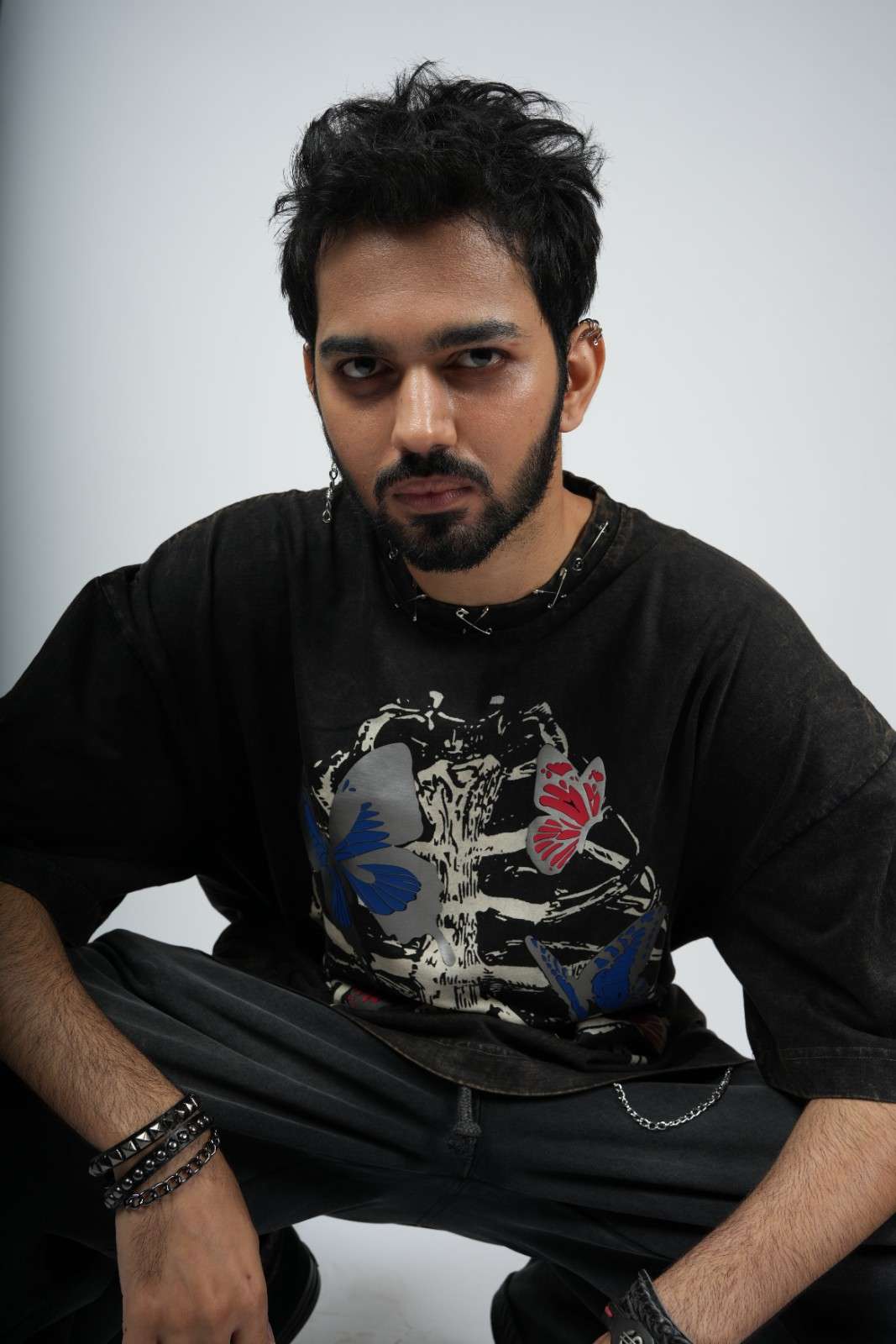 Man wearing a black t-shirt with butterfly design on a white background