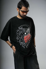 Man wearing a black t-shirt with a graphic design on a gray background