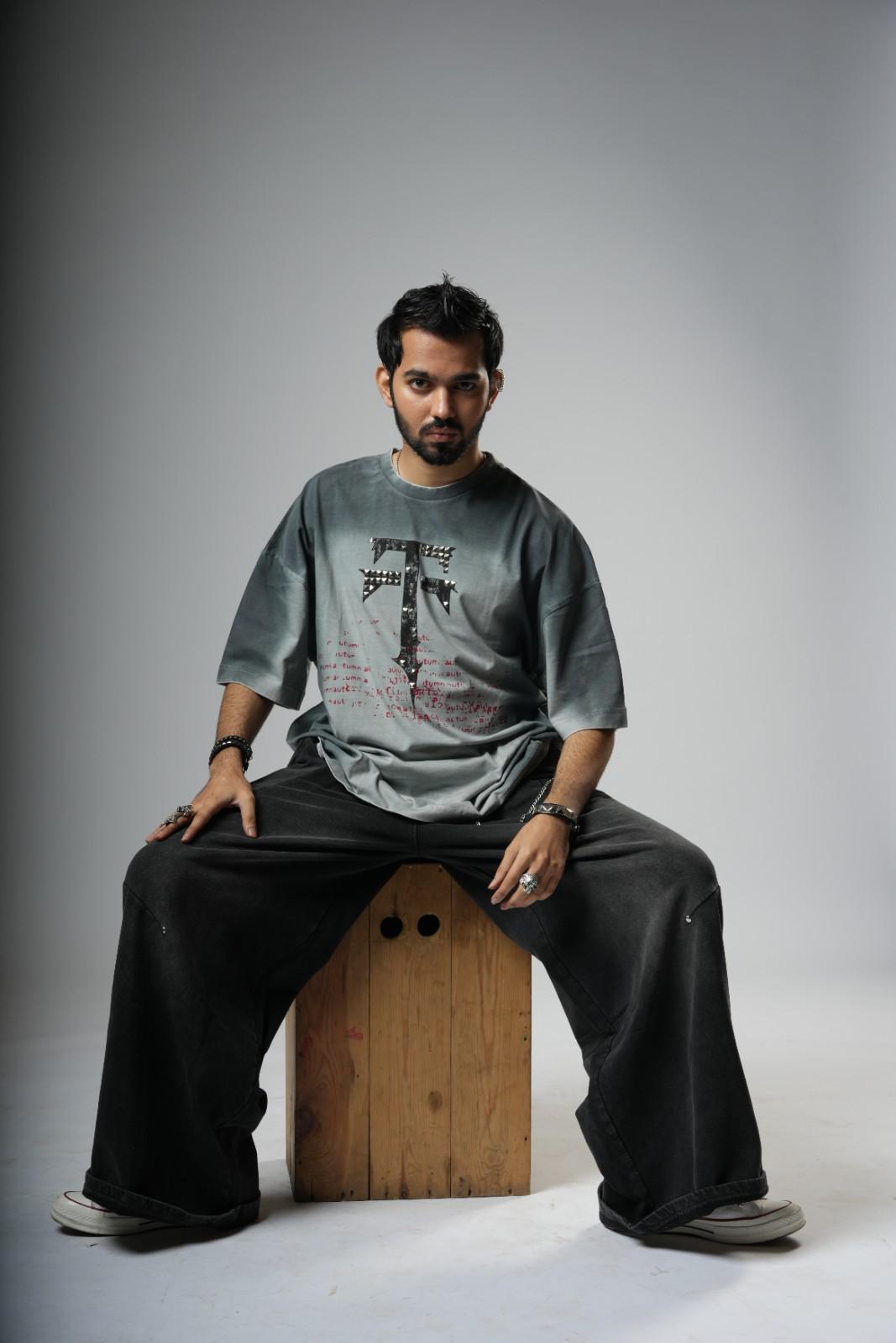 Man sitting on a wooden block against a plain background
