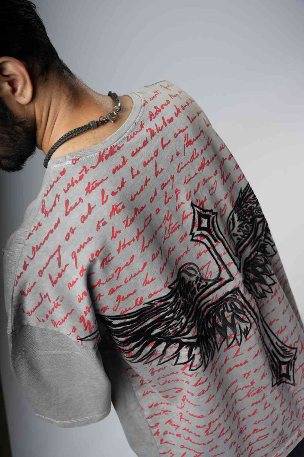Person wearing a sweater with red text and black eagle design on a plain background