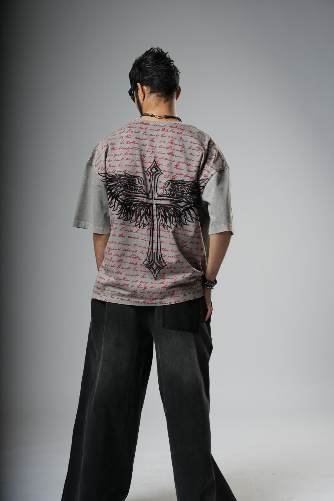 Person wearing a patterned shirt with a cross design on a gray background