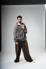 Man wearing a gray hoodie and brown pants on a white background