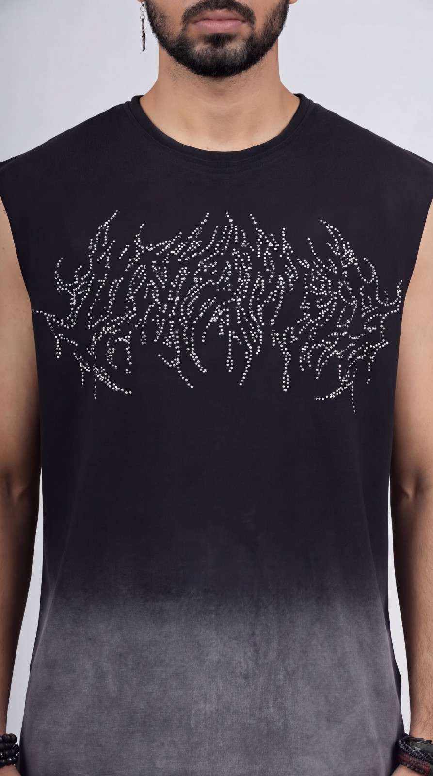 Black sleeveless shirt with silver embellishments on a gradient background